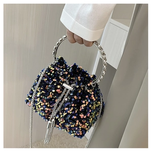 Detail view of colorful sequin bucket bag with silver metal handle and drawstring close