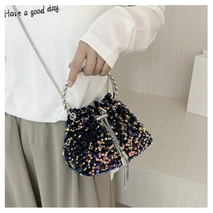 Detail of colorful sequin bucket bag with silver metal ring handle and fringe