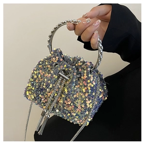 Detail of sequin bucket bag with rhinestone ring handle and elegant metal chain tassel