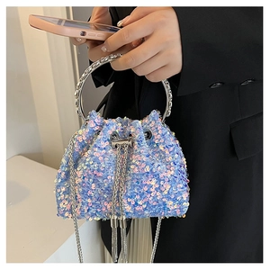 Detail view of iridescent blue sequin bucket bag with silver ring handle and tassel chain
