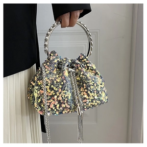 Detail of colorful sequin bucket bag featuring silver round handle and metal tassel chain