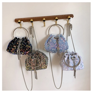 Detail of sequined bucket bags in four colors with metal handles and chain straps