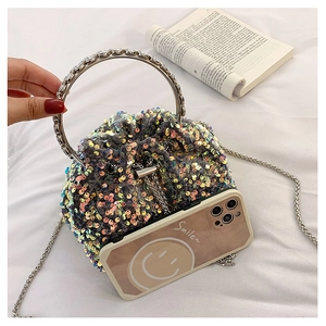 Detail of colorful sequin bucket bag with metal handle and phone for size reference