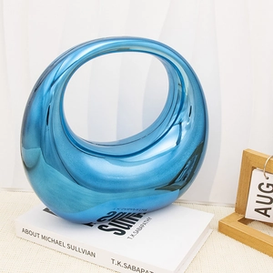 Detail of blue metallic mirror acrylic moon bag with asymmetrical ring handle design