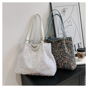 Détail de grands sacs cabas à paillettes blanc et gris foncé avec reflets laser irisés
