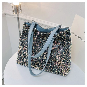 Détail du sac cabas à paillettes colorées avec lanières en cuir bleu clair et zip