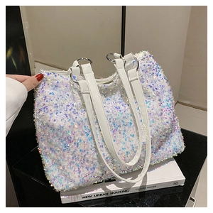 Gros plan détaillé des paillettes irisées sur un grand sac cabas blanc avec sangles