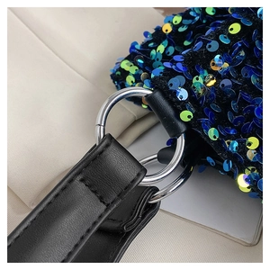 Détail de paillettes bleu-vert et lanières en cuir noir avec anneaux métalliques