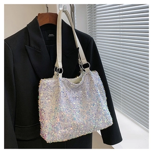 Détails des paillettes blanches et anneaux métalliques sur un sac cabas holographique