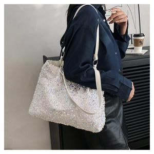 Détail du cabas à paillettes blanches irisées avec reflets métalliques et anses en cuir