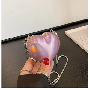 Macro view of heart-shaped laser acrylic mini bag with silver chain strap and holographic finish