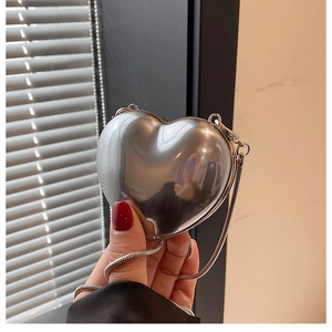 Macro shot of silver mirror heart-shaped mini acrylic bag with fine metal chain strap