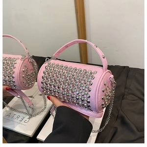 Detail of pink cylindrical bucket bag with silver studs and metal chain strap