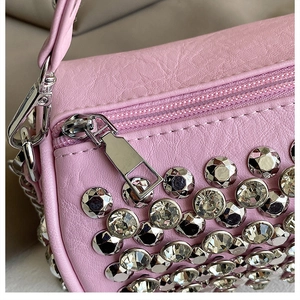Detail of pink leather cylinder bag with rhinestone embellishments and silver zipper