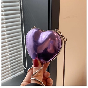 Detail of purple metallic heart-shaped mini bag with silver snake chain for cross-body wear