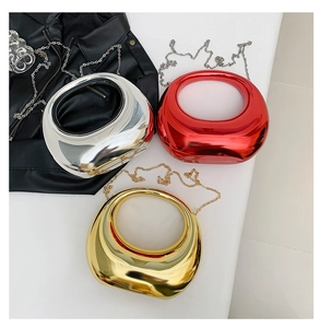 Close-up of three acrylic evening bags in gold, silver, and red with metal handles
