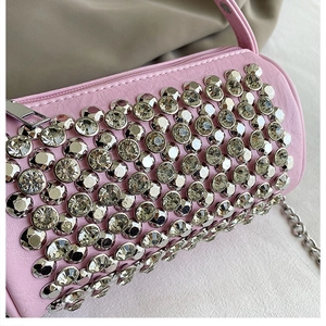 Detail of pink cylindrical rhinestone bag with silver studs and metal chain strap