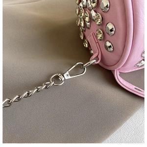 Detail of pink cylindrical leather bag with silver studs and chain strap clip
