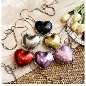 Close-up of heart-shaped mini acrylic crossbody bags in vibrant metallic colors
