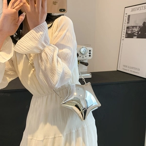 Nahaufnahme der silbernen sternförmigen Acryltasche mit glänzendem Spiegel-Finish und Kette