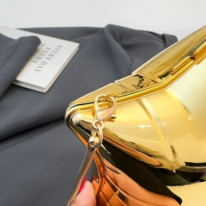Makro-Detail der goldenen geometrischen Acryl-Clutch mit Plattierung und Schlangenkette