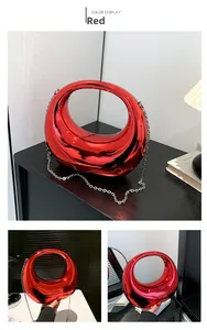 Detail of a bright metallic red acrylic crescent moon evening bag with silver chain strap