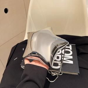 Makroaufnahme der silbernen Acryl-Abendtasche in Sternform mit glänzendem Spiegeleffekt