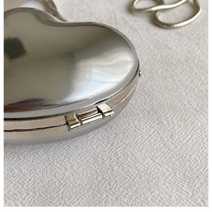Detail view of the silver heart-shaped acrylic mini bag with textured metallic finish