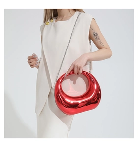 Detail of metallic red acrylic clutch with hollow handle and silver chain strap