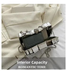 Detail view of silver acrylic hard shell evening bag with chain showing interior capacity