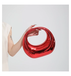 Close-up of a red acrylic moon-shaped handbag with a high-gloss metallic mirror finish