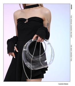 Close-up of a clear acrylic crescent moon bag featuring a sleek metal chain strap
