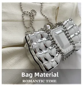 Close-up of silver acrylic clutch bag with faceted diamond texture and pearl clasp