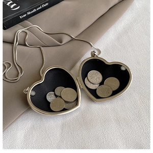Detail of mini heart acrylic purse with silver chain showing coin storage capacity