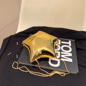 Detailaufnahme einer goldfarbenen Abendtasche in Sternform mit spiegelnder Oberfläche