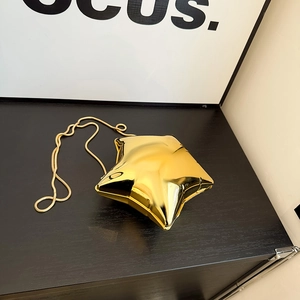 Detail einer glänzenden goldenen Abendtasche in Sternform mit eleganter Metallkette