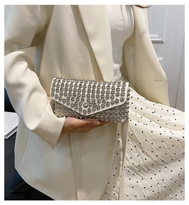 Détail du sac bandoulière blanc à strass montrant les cristaux et le rabat en V chic