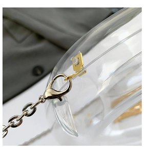 Detail of transparent acrylic crescent bag with premium gold metal chain and lobster clasp