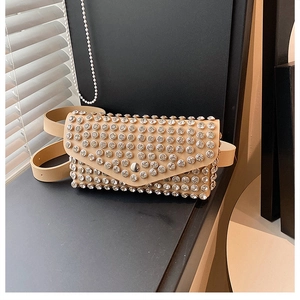 Gros plan d'un sac ceinture beige orné de strass avec bandoulière en cuir chic