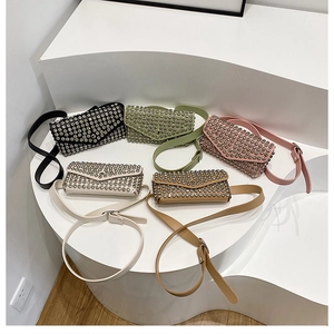 Détail de sacoches de ceinture cloutées en cinq couleurs sur un support minimaliste