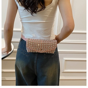 Détail du sac banane rose à strass porté à la taille avec un design à rabat élégant