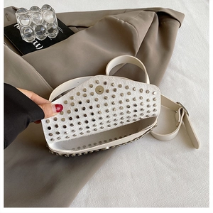 Détail du sac bandoulière crème avec rivets argentés et fermeture magnétique chic
