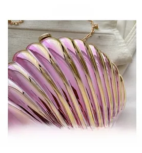 Detailed close-up of shell-shaped evening bag with gradient pink and gold metallic texture