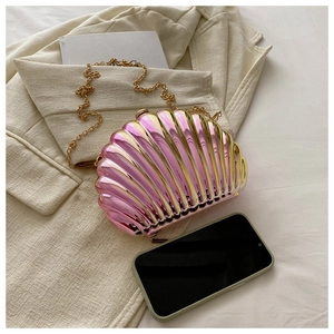 Detailed view of a gradient shell evening bag next to a smartphone for size reference