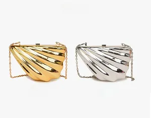 Detail view of gold and silver shell-shaped acrylic clutch bags with chain straps