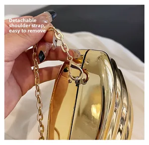 Detail of the detachable gold chain strap on the stylish acrylic evening clutch bag