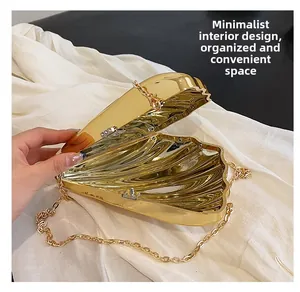 Detail of the golden shell-shaped acrylic clutch interior with chain strap and hinge