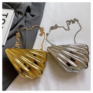 Detailed view of glossy shell-shaped acrylic evening bags in gold and silver metallic finishes