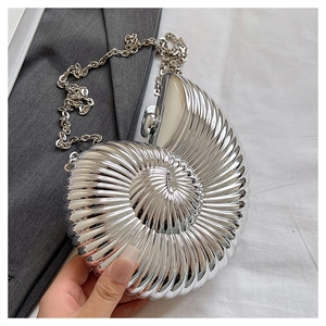Macro detail of silver shell evening clutch bag with metallic texture and chain