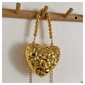 Golden heart-shaped acrylic evening bag with hammered texture and beaded handle